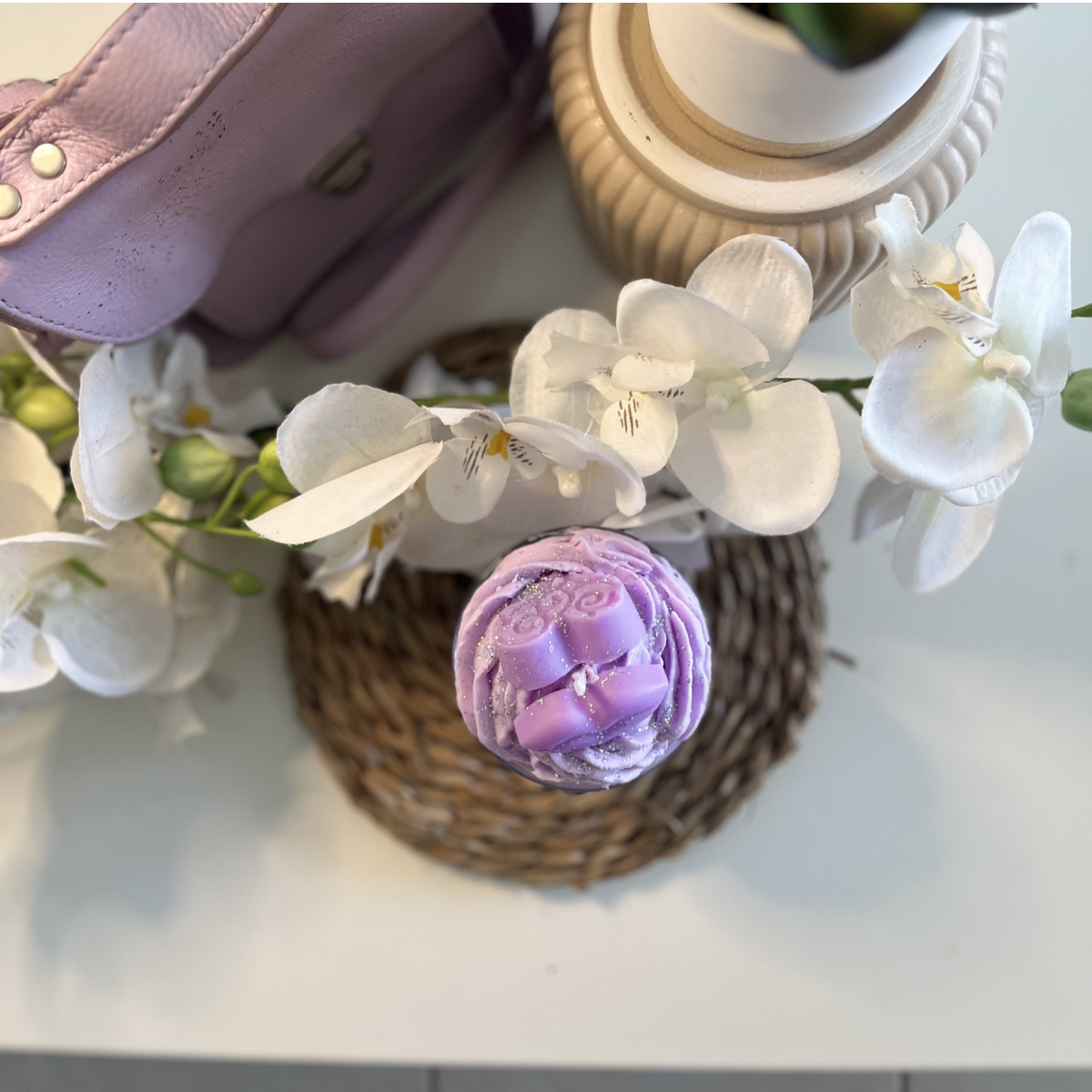 Bougie passion lilas sur fond neutre, montrant sa teinte lilas délicate et son design artisanal.